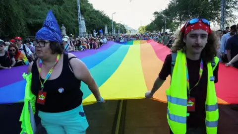 Reuters Crowd in Budapest marches with giant rainbow flag for Pride