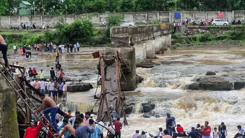 AFP/ Getty Images People gather near the site of a bridge collapse at Indrayani river near Kundamala village 