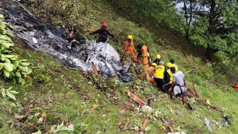 Reuters Members of rescue teams work at the site of a helicopter crash 