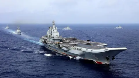 Reuters A 2018 photo of the Chinese aircraft carrier Liaoning in the western Pacific Ocean taking part in a military drill, with other military vessels surrounding it