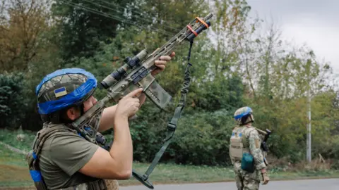 Global Images Ukraine via Getty Images A Ukrainian serviceman looks through the scope of a rifle on September 11, 2024 in Sudzha, Kursk Region, Russia. 