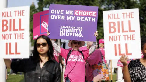 EPA Campaigners and demonstrators in favour and against the assisted dying bill hold placards as they gather in Parliament Square in London