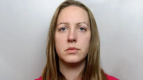 Cheshire Police Lucy Letby's police mugshot from the time of her arrest. She has long blonde hair and blue eyes and is staring straight at the camera.