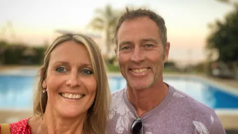 Family handout A man and woman pose in front of a swimming pool. 