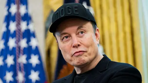 Getty Images Elon Musk looks on during a news conference with US President Donald Trump in the Oval Office of the White House in Washington, in May 2025
