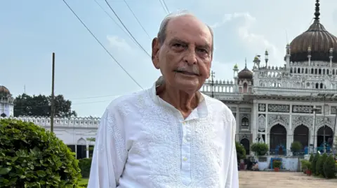 Aman/BBC Faiyaz Ali Khan stands in front of the Bara Imambara in Lucknow 