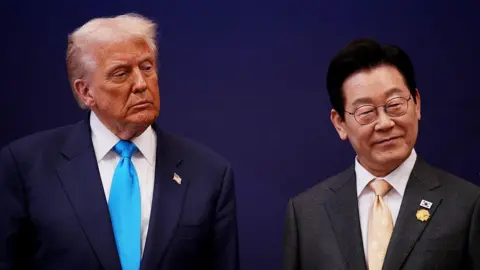 Getty Images U.S. President Donald Trump smiles as he stands next to  South Korean President Lee Jae Myung
