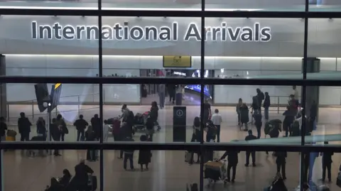 EPA-EFE/REX/Shutterstock The photo has been taken through a glass window and shows the 'International Arrivals' zone of Heathrow airport