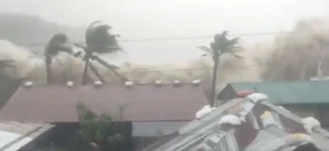 A screengrab from a video showing large waves lashing a village in the Philippines
