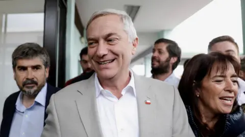 Reuters Jose Antonio Kast, presidential candidate of the far-right Republican Party of Chile, and his wife Maria Pia Adriasola Barroilhet, arrive at a polling station to vote during a presidential runoff election