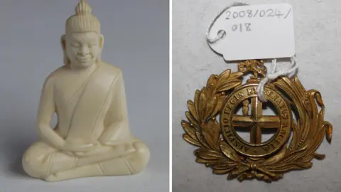 Bristol Museum A carved ivory buddha with a topknot and robes in a cross-legged position. It sits next to a circular belt buckle with a laurel motif with the words "Auspicio Regis et Senatus Angliae".