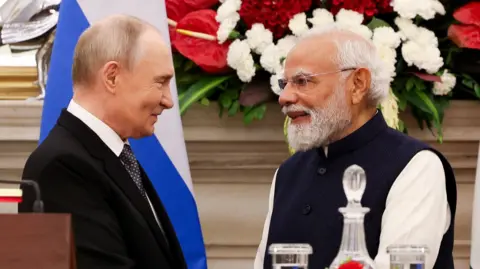 Reuters Russian President Vladimir Putin and India's Prime Minister Narendra Modi shake hands as they attend a presentation of a joint statement after their delegation level talks at Hyderabad House in New Delhi, India, December 5, 2025.