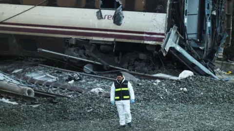 Reuters A member of the Spanish Civil Guard stands near the wreckage of a train involved in the accident, at the site of a deadly derailment of two high-speed trains near Adamuz