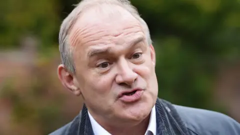 PA Media Liberal Democrats leader Sir Ed Davey, wearing a dark green jacket, is pictured speaking
